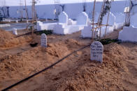 A view of the cemetery for migrants who have died trying to reach Europe, in the village of Zarzis, Saturday June 12, 2021. A newly sanctified cemetery for Tunisia's migrant dead is filling quickly. Rachid Koraïchi bought the plot of land in the port city of Zarzis a few years ago and started designing what he hoped would be the final resting place for people who died on the move. Most of the headstones have dates but no names. (AP Photo/Mehdi El Arem)