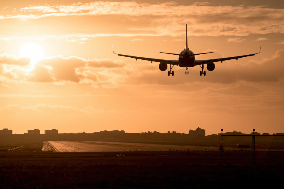 Background of an airplane landing at sunset, high contrast image
