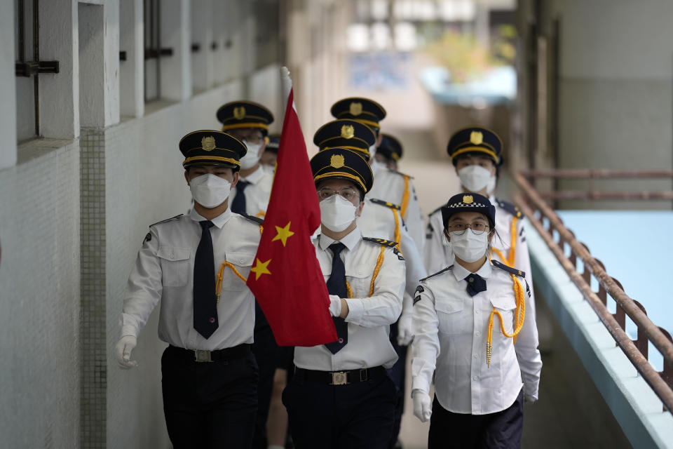 Students wearing face masks attend a Chinese national flag raising ceremony during at a secondary school to mark the 25th anniversary of Hong Kong handover to China, in Hong Kong, Thursday, June 30, 2022. (AP Photo/Kin Cheung)