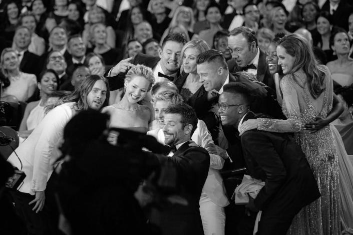 Ellen DeGeneres, hosting the Academy Awards in March 2014, gathers celebrities in the audience for a selfie.