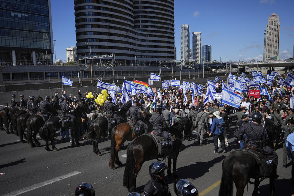 Mounted police try to disperse demonstrators as they block a highway during a protest against plans by Prime Minister Benjamin Netanyahu's government to overhaul the judicial system, in Tel Aviv, Israel, Thursday, March 9, 2023. (AP Photo/Ohad Zwigenberg)