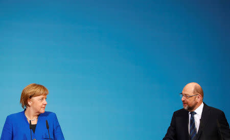 Acting German Chancellor Angela Merkel and Social Democratic Party (SPD) leader Martin Schulz attend a news conference after exploratory talks about forming a new coalition government at the SPD headquarters in Berlin, Germany, January 12, 2018. REUTERS/Hannibal Hanschke