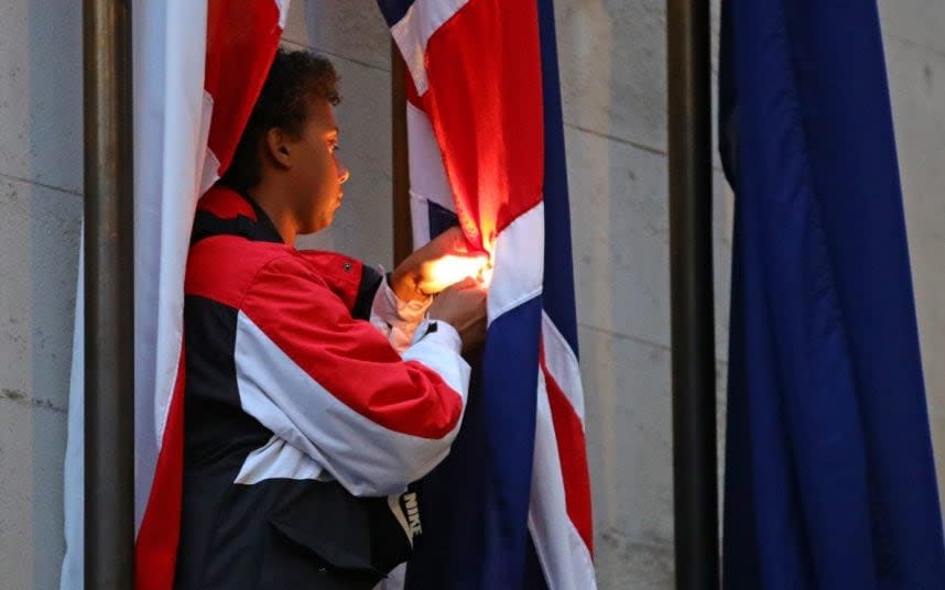 A protester attempts to burn a flag at the Cenotaph in Whitehall. - AARON CHOWN/PA