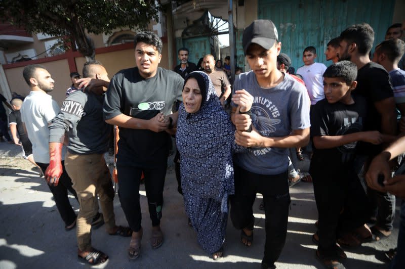 Rescuers and people transport a victim recovered from under the rubble of a collapsed house following an Israeli airstrike on Rafah in southern Gaza Strip on Thursday. Photo by Ismael Mohamad/UPI