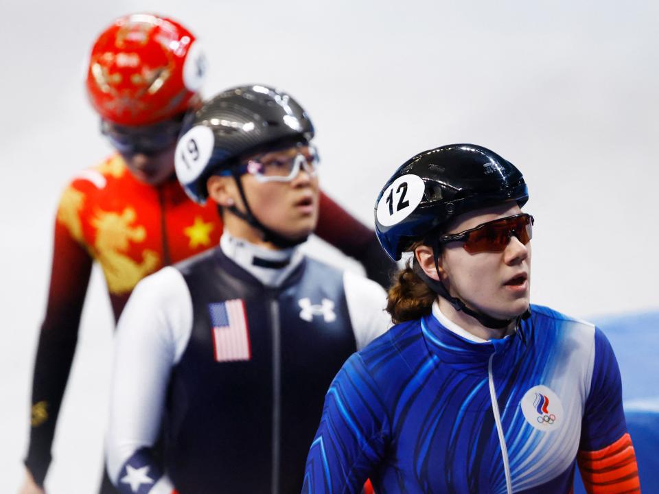 ROC (right) and US (center) athletes react to receiving penalties after finishing ahead of the pack in the mixed team relay semifinal.