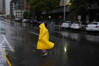 A woman walks under the rain in Caracas, Venezuela, Wednesday, June 29, 2022. As the latest tropical disturbance advances through the area, Venezuela shuttered schools, opened shelters and restricted air and water transportation as President Nicolas Maduro noted that the South American country already has been struggling with recent heavy rains. (AP Photo/Ariana Cubillos)