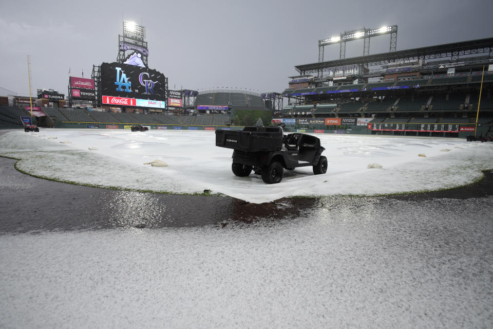 Hail covers a tarpaulin and the field after a summer storm packing heavy rain, high winds and large hail swept over Coors Field, Thursday, June 29, 2023, in Denver. The Colorado Rockies were set to host the Los Angeles Dodgers, Thursday. (AP Photo/David Zalubowski)