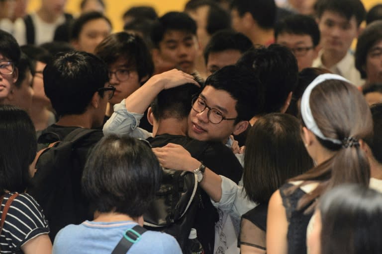 Nathan Law (C), a leader of Hong Kong's 'Umbrella Movement', hugs a supporter before his sentencing at the High Court in Hong Kong on August 17, 2017