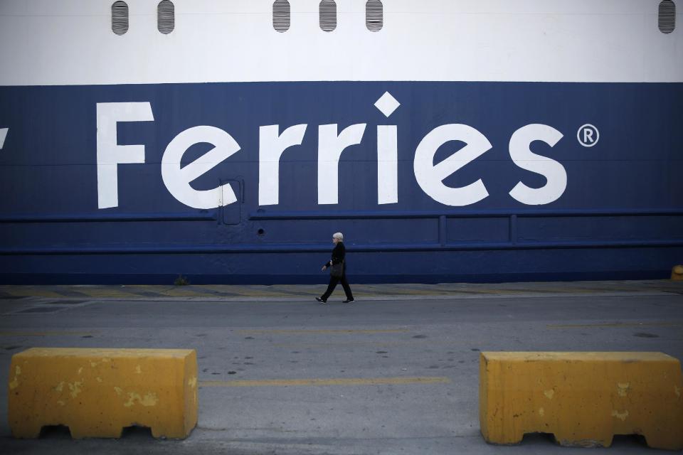 A woman walks past a docked ship at the port of Piraeus, near Athens during a 24-hour nationwide general strike, Wednesday, April 9, 2014. Greek unions have launched an anti-austerity general strike that has halted train and island ferry services while disrupting state hospitals and other public services. Wednesday's 24-hour strike is also causing public transport disruptions in Athens, where unionists are planning two separate protest marches to Parliament.(AP Photo/ Petros Giannakouris)