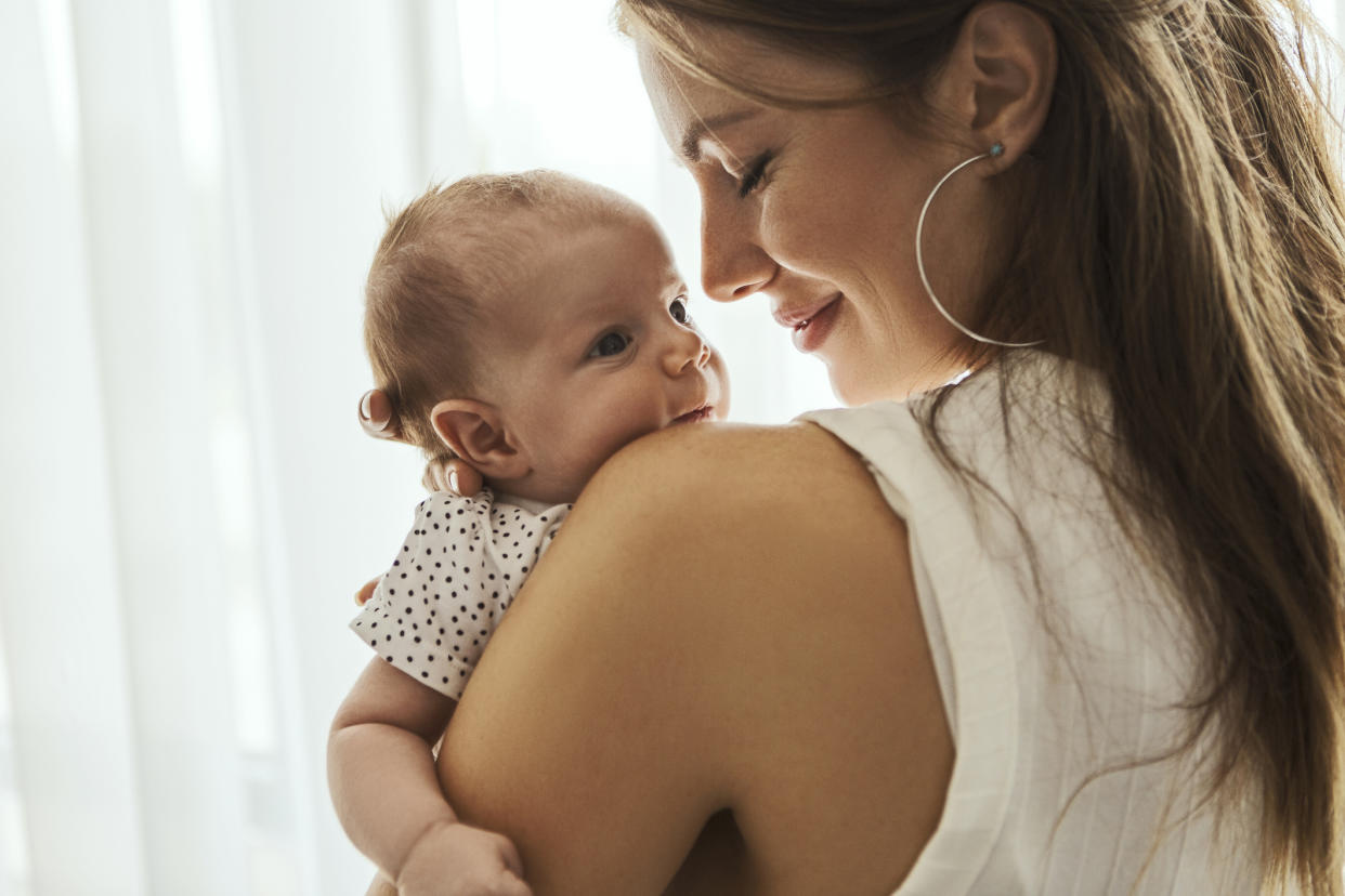 Mum cuddling her baby, as parents share their 'guilty pleasure' baby names. (Getty Images)