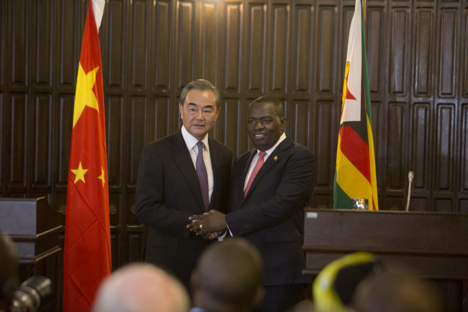 Chinas Foreign Minister Wangi Yi, left, greets Zimbabwe's Foreign minister Sibusiso Moyo after a joint press conference in Harare, Zimbabwe, Sunday, Jan, 12, 2020. Wangi Yi is in Zimbabwe as part of a five nation tour of Africa that seeks to promote the Asian economic and political interests on the continent. (AP Photo/Tsvangirayi Mukwazhi)