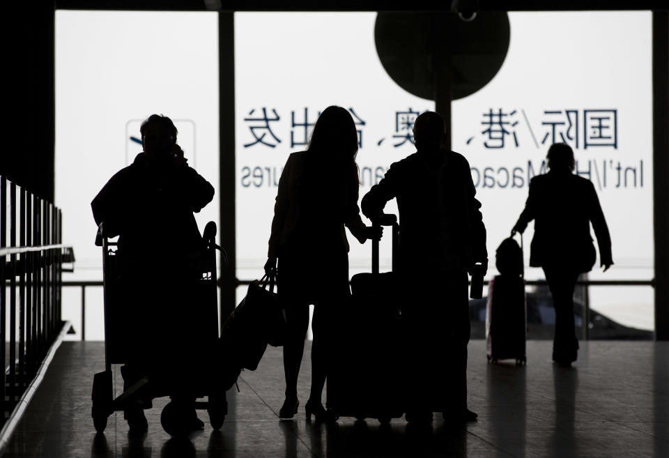 In this April 10, 2014 photo, passengers with their luggage arrive at the Beijing Capital International Airport in Beijing, China. At airports across Asia and around the world, Flight 370 and its 239 passengers and crew, now lost for more than a month, are topics of avid speculation and sometimes anxiety. Passengers typically remain confident about the safety of air travel, but some are distressed by the disappearance, which - given the number of people involved - is unprecedented in aviation industry. (AP Photo/Andy Wong)