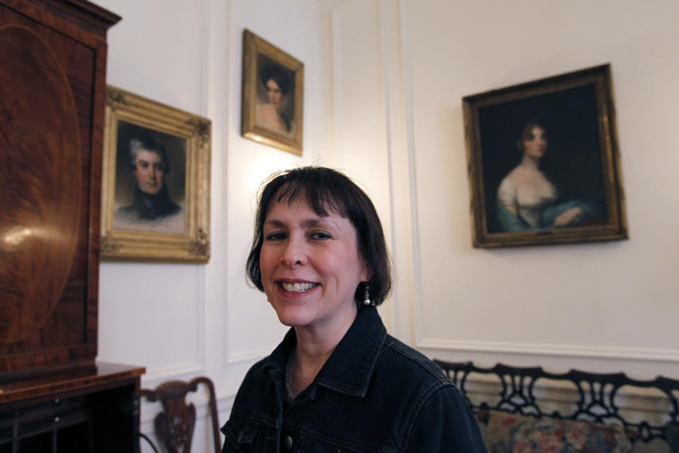 In this March 13, 2012 photo, Judith M. Guston poses for a photograph with a portrait of Maria Gratz, top center, in the Rosenbach Museum & Library in Philadelphia. The portrait of Gratz by Thomas Sully joins nine others of the Gratz family at the museum. (AP Photo/Alex Brandon)