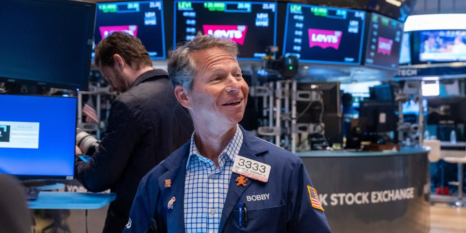 A smiling trader on the floor of the New York Stock Exchange.