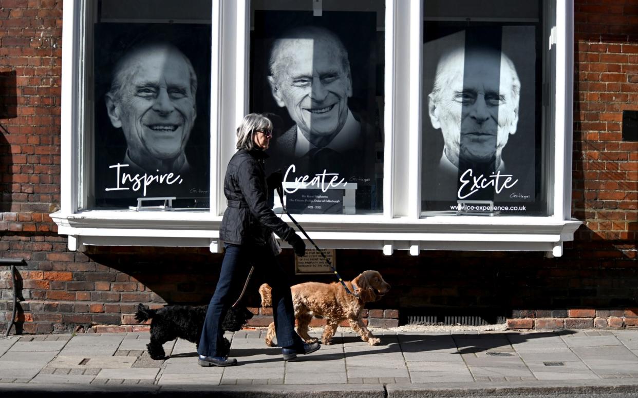 A view of a woman passing a shop window in Windsor with tributes to Prince Philip - Kate Green/Getty Images