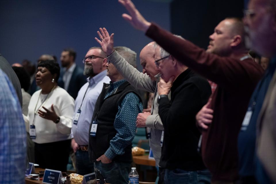 Executive committee members raise their hands in praise during the Southern Baptist Convention Executive Committee meeting Monday, Feb. 20, 2023 in Nashville, Tenn. 