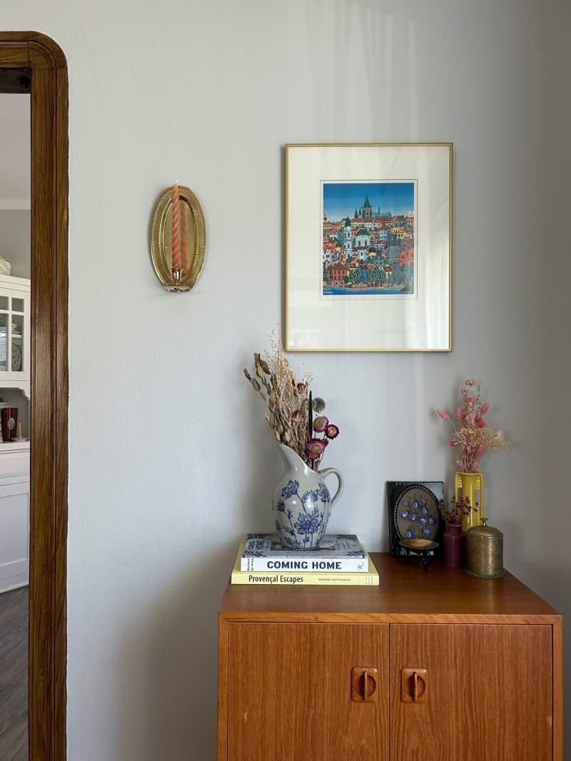 Dried flowers in vase on side table in vintage inspired home.