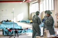Medical personnel work inside one of the emergency structures that were set up to ease procedures at the hospital of Brescia, Northern Italy, Tuesday, March 10, 2020. For most people, the new coronavirus causes only mild or moderate symptoms, such as fever and cough. For some, especially older adults and people with existing health problems, it can cause more severe illness, including pneumonia. (Claudio Furlan/LaPresse via AP)