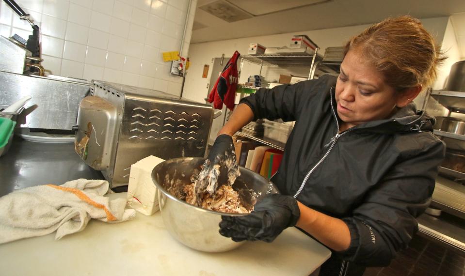 Lucy Coria makes churro cream cheese early Thursday morning, Dec. 15, 2022, at De Coria's Bagels in Belmont.
