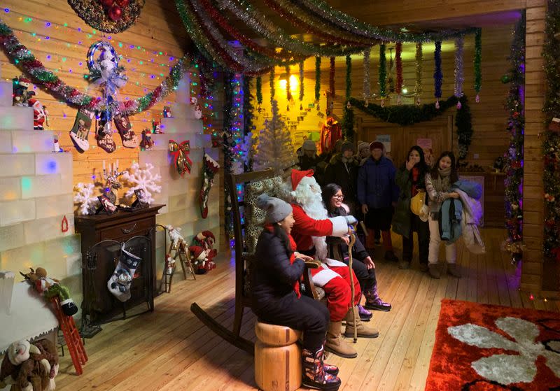 Visitors line up for a photo taking session with Santa, played by Ville Haapassallo, from Finland, inside the Santa Claus House at a Christmas theme park on the outskirts of Mohe,
