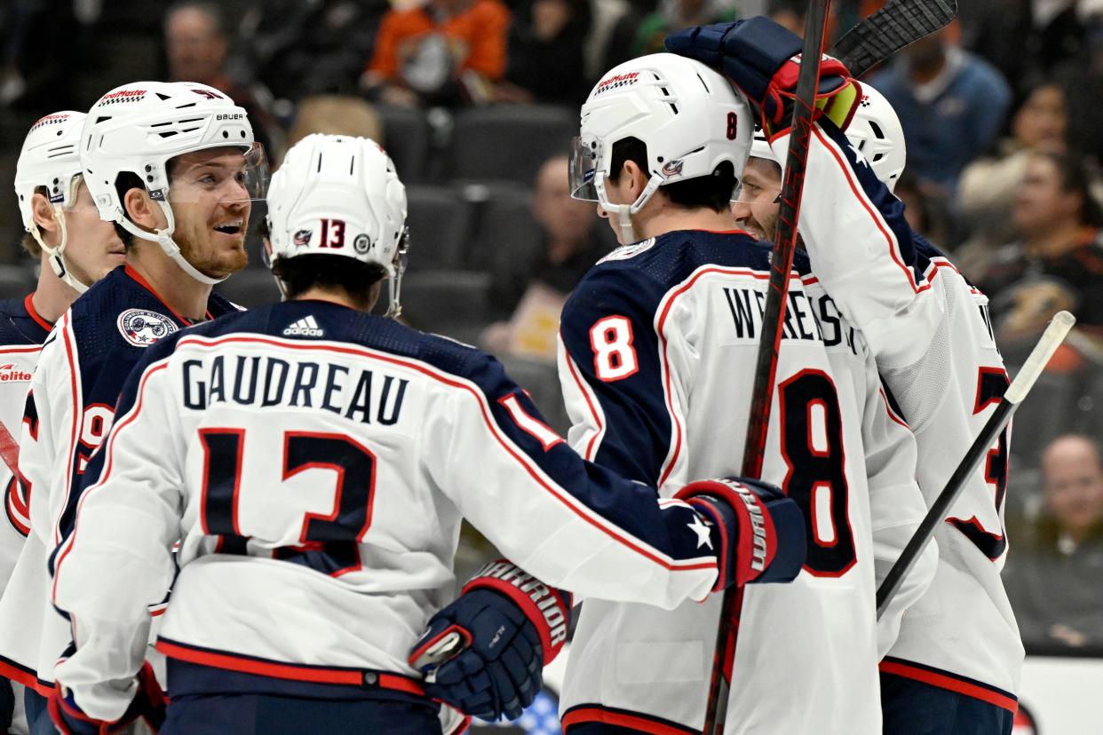 Columbus Blue Jackets center Jack Roslovic, second from left, celebrates a goal by defenseman Zach Werenski (8) with left wing Johnny Gaudreau (13) and center Boone Jenner, right, against the Anaheim Ducks during the first period of an NHL hockey game in Anaheim, Calif., Wednesday, Feb. 21, 2024. (AP Photo/Alex Gallardo)