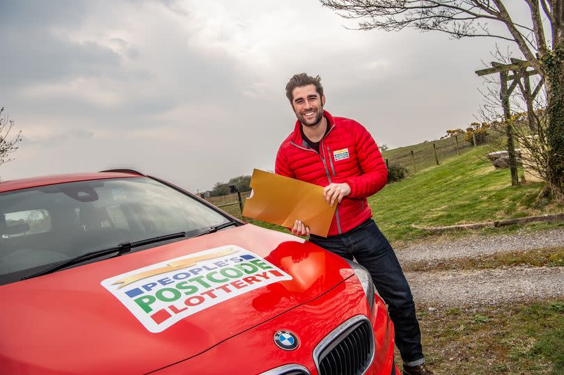 Postcode Lottery Ambassador with an envelope