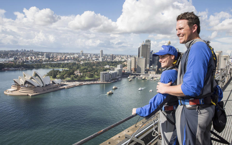 In this photo released by Destination NSW, Arizona Diamondbacks' pitcher Will Harris with his wife enjoys viewing from the Sydney Harbour Bridge in Sydney, Thursday, March 20, 2014. The Diamondbacks will play the Los Angeles Dodgers in their Major League Baseball season opening games at the Sydney Cricket Ground on Saturday and Sunday. (AP Photo/Destination NSW, James Horan)