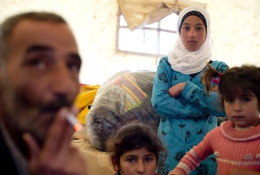 A Syrian refugee family gathers inside a tent after arriving to the Turkish side of the Orontes river after fleeing from the northern Syrian town of Darkush on December 13, 2012. The number of Syrian refugees registered in neighbouring countries and North Africa has passed half a million, the UN's refugee body said, adding that many more have not come forward to seek help. AFP PHOTO / ODD ANDERSEN (AFP | Odd Andersen)