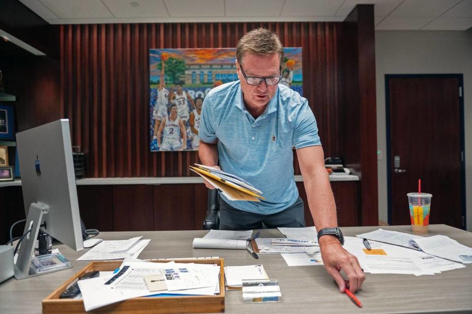 Before a tour of his office, Bill Self tidies up his desk to make it more presentable.