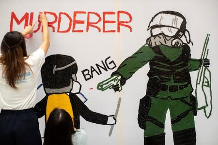 Anti-government protesters make a mural depicting the student protester who got shot by police with live ammunition in Hong Kong