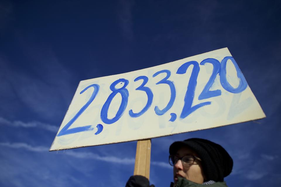 HARRISBURG, PA - DECEMBER 19:   Anya Rose, 33, holds a sign with the number of votes Hillary Clinton won the popular vote, joining Donald Trump protestors demonstrating outside the Pennsylvania Capitol Building before electors arrive to cast their votes from the election at December 19, 2016 in Harrisburg, Pennsylvania.  Electors from all 50 states cast votes today in their respective state capitols.  Donald J. Trump won Pennsylvania by less than 1%, the first Republican to carry the state since George H. W. Bush 1992.  (Photo by Mark Makela/Getty Images)