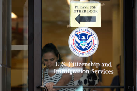 FILE PHOTO: A woman leaves the U.S. Citizenship and Immigration Services offices in New York, August 15, 2012. REUTERS/Keith Bedford/File Photo