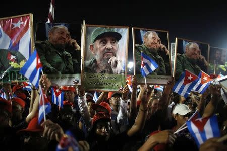 People hold up images of former Cuban leader Fidel Castro at a tribute to Castro in Santiago de Cuba, Cuba, December 3, 2016. REUTERS/Alexandre Meneghini