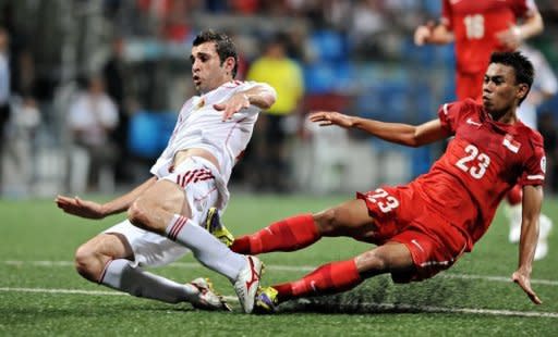 Jordanian foward Ahmed Hayel (L) is tackled by Singaporean defender Juma'at Jantan (R) during their 2014 World Cup Asian qualifying round three football match in Singapore. Jordan won 3-0