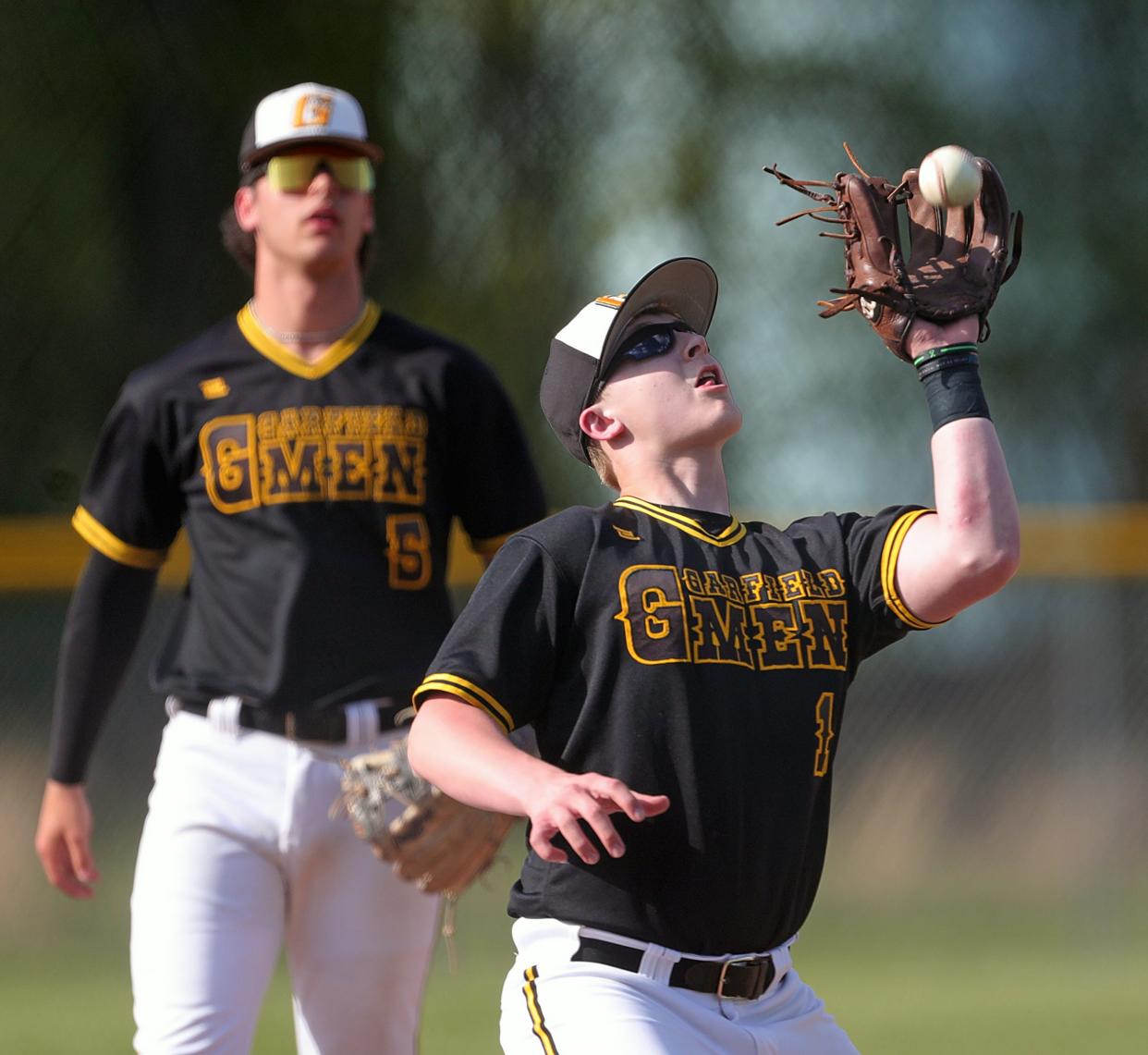 Garfield third baseman Tyler Lutz gets under a fly ball hit by Mogadore batter Austin Constantine during the first inning of a high school baseball game, Wednesday, May 1, 2024, in Garrettsville, Ohio.