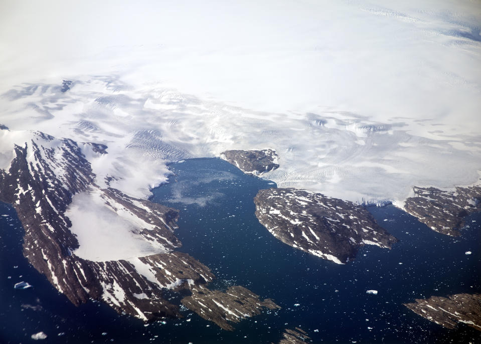 FILE - In this Thursday, Aug. 3, 2017 file photo, a glacier calves icebergs into a fjord off the Greenland ice sheet in southeastern Greenland. Scientists from 17 nations are preparing for a year-long mission to the central Arctic to study the impact that climate change is having on the frigid far north of the planet. Mission leader Markus Rex said that researchers plan to anchor the German icebreaker RV Polarstern to a large floe and set up camp on the ice as the sea freezes around them, conducting experiments throughout the Arctic winter. (AP Photo/David Goldman, File)