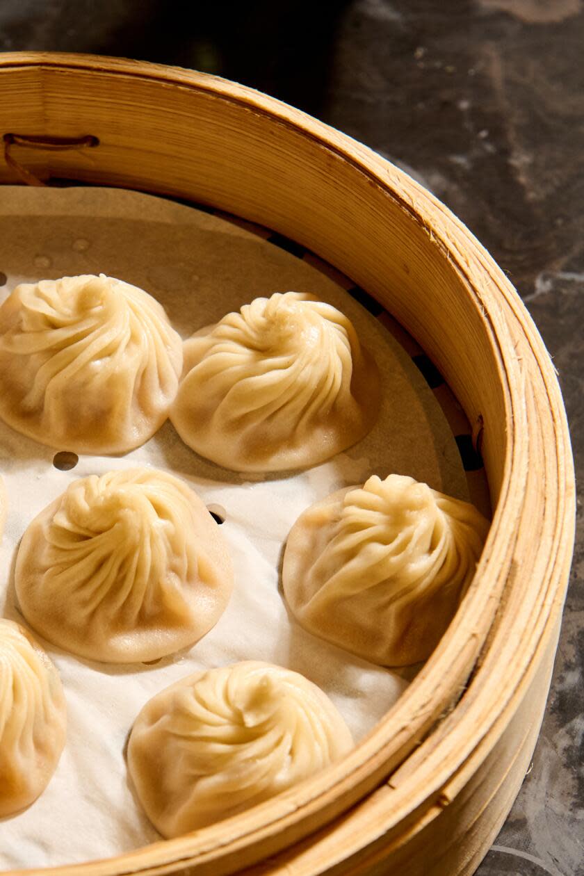 Soup dumplings in a steamer basket, seen in closeup