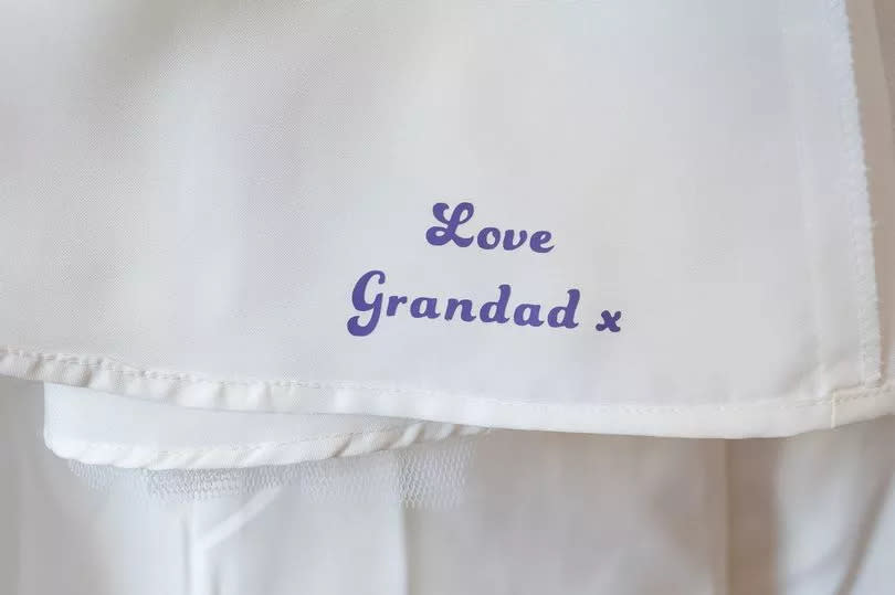 Amy had 'Love Grandad' put on her dress in purple lettering on the end of the train