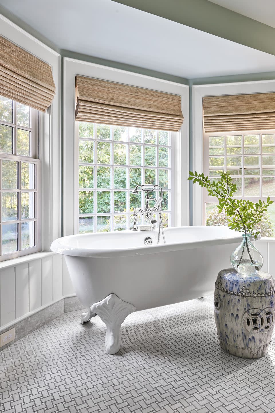 bathroom with white clawfoot tub and tile floor laid in a basketweave pattern