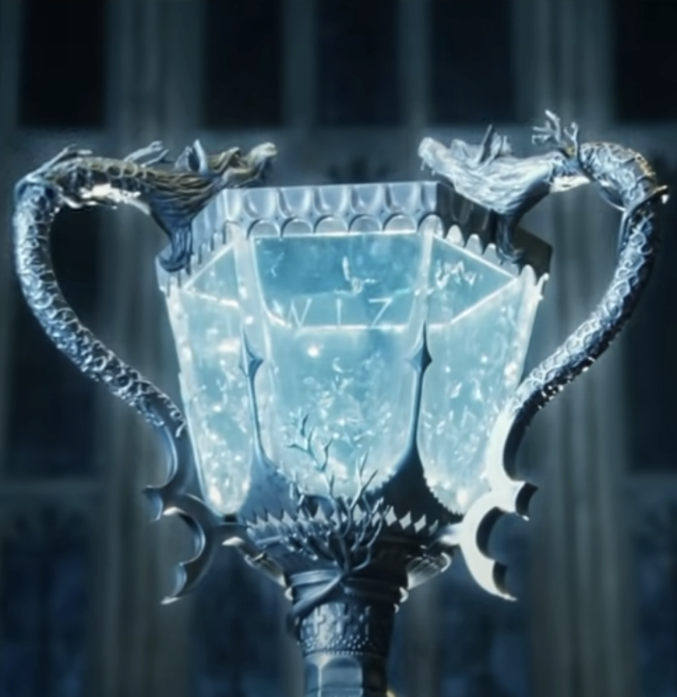 Intricately designed trophy with eagle-shaped handles, displayed against a blurred backdrop