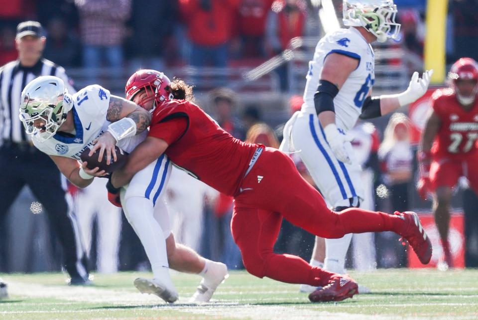 Louisville Cardinals defensive lineman Ashton Gillotte (9) brings down Kentucky Wildcats quarterback Devin Leary (13) for a sack in the first half Saturday. Nov. 25, 2023.