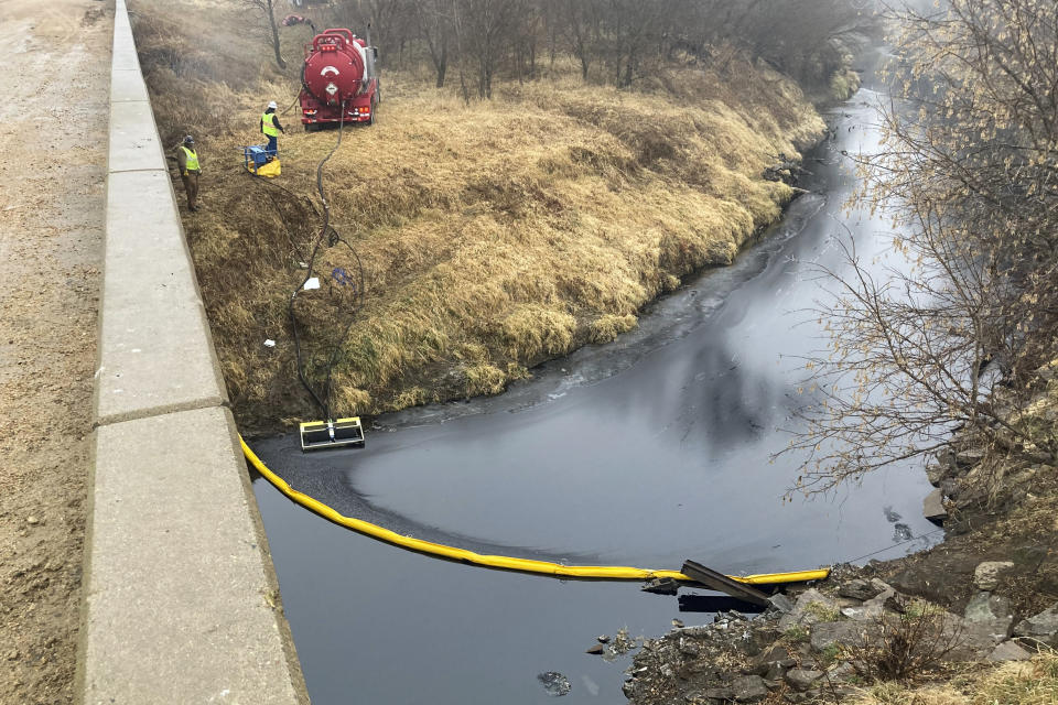 A remediation company deploys a boom on the surface of an oil spill after a Keystone pipeline ruptured at Mill Creek in Washington County, Kansas, on Thursday, Dec. 8, 2022. Vacuum trucks, booms and an emergency dam were constructed on the creek to intercept the spill. (Kyle Bauer/KCLY/KFRM Radio via AP)