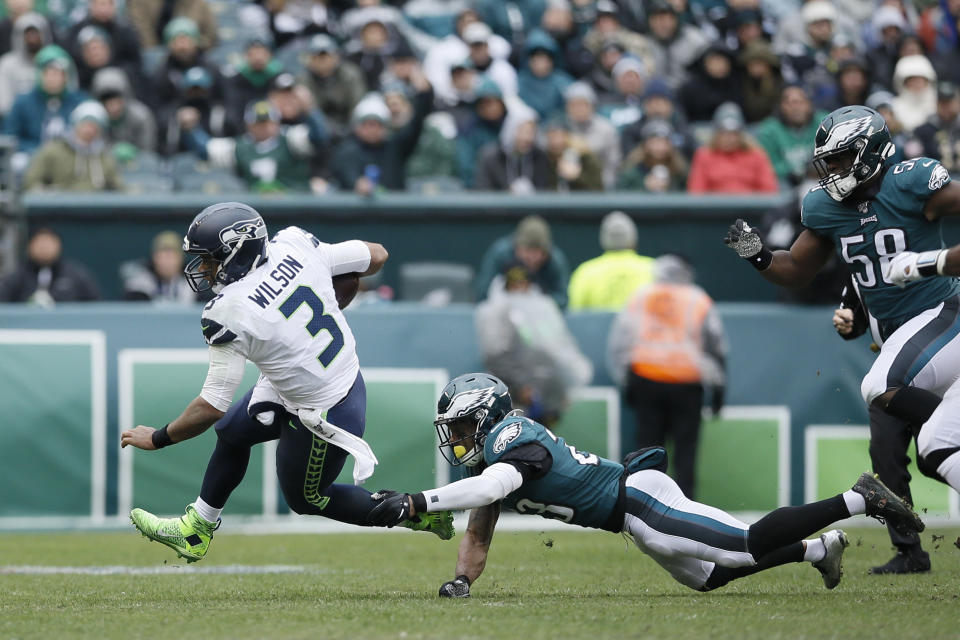 Seattle Seahawks' Russell Wilson, left, tries to avoid Philadelphia Eagles' Rodney McLeod during the first half of an NFL football game, Sunday, Nov. 24, 2019, in Philadelphia. (AP Photo/Michael Perez)
