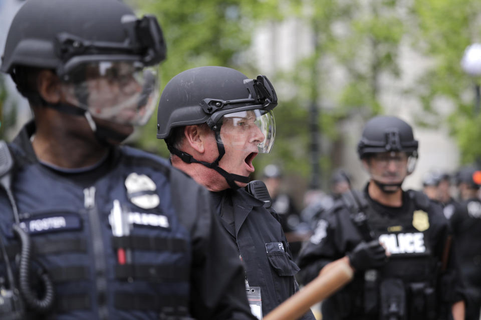 FILE - In this June 3, 2020, file photo, a Seattle police officer yells out orders at Seattle City Hall as protesters march toward them, in Seattle, following protests over the death of George Floyd, a black man who was in police custody in Minneapolis. The King County Labor Council, the largest labor group in the Seattle area, vote Wednesday night June 17 to expell the city’s police union, saying the guild representing officers failed to address racism within its ranks. (AP Photo/Elaine Thompson, File)