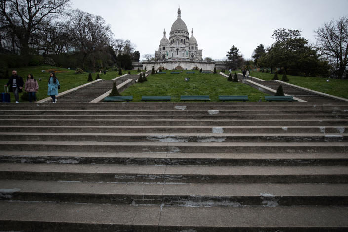 Tourists go down the deserted stairs of the Sacre Coeur Basilica in the district of Montmartre in Paris.