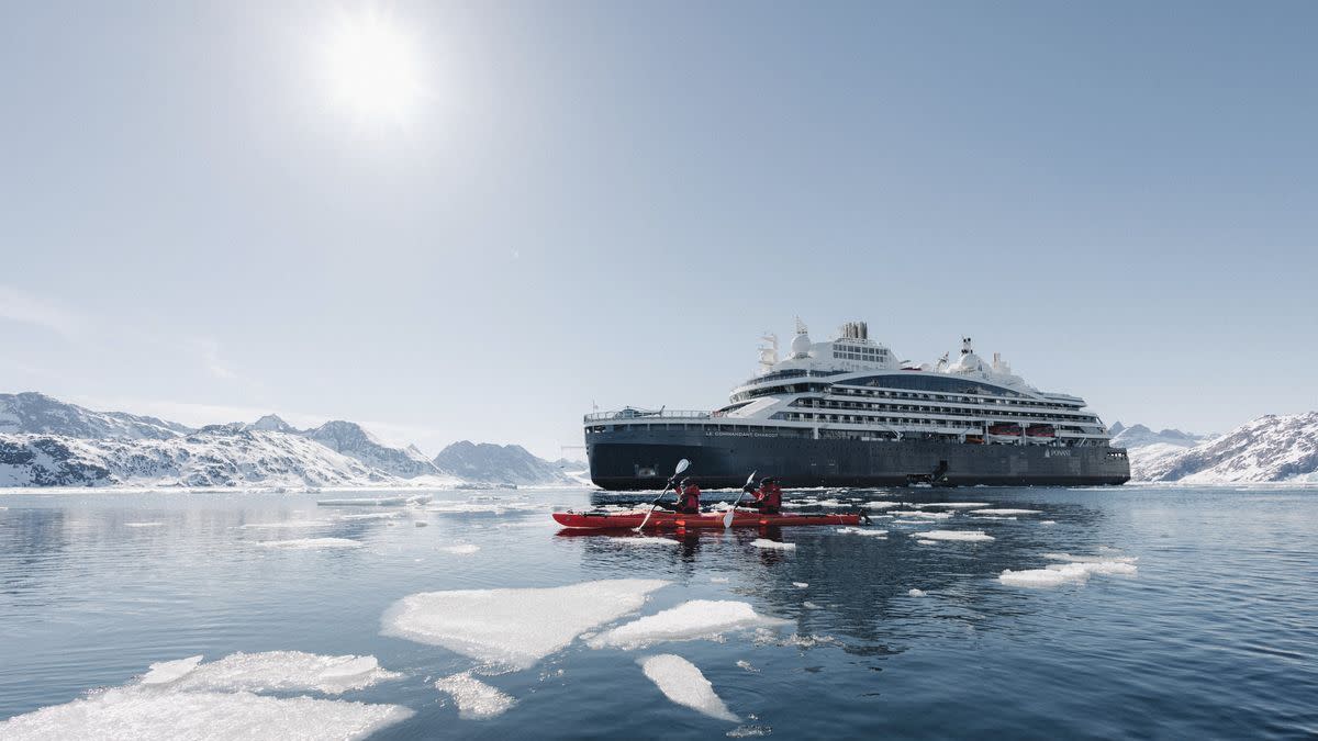 a boat in the water with a large cruise ship in the background