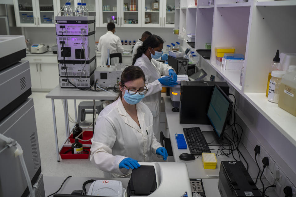 Scientists conduct research at an Afrigen Biologics and Vaccines lab in Cape Town, South Africa, Tuesday Oct. 19, 2021. In a pair of warehouses converted into a maze of airlocked sterile rooms, young scientists are assembling and calibrating the equipment needed to reverse engineer a coronavirus vaccine that has yet to reach South Africa and most of the world's poor. (AP Photo/Jerome Delay)