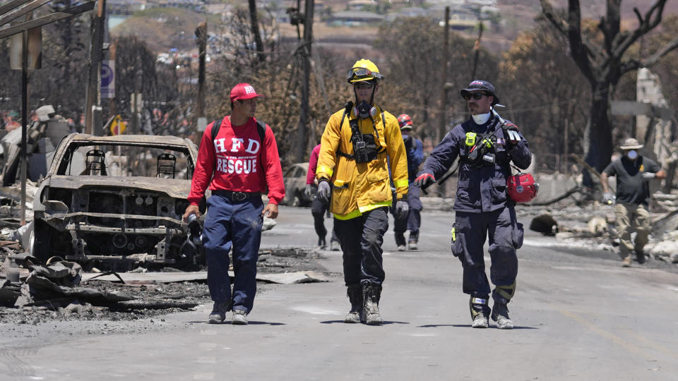 Members of a search-and-rescue team walk along a street on Aug. 12, 2023, in Lahaina, Hawaii. / Credit: Rick Bowmer / AP