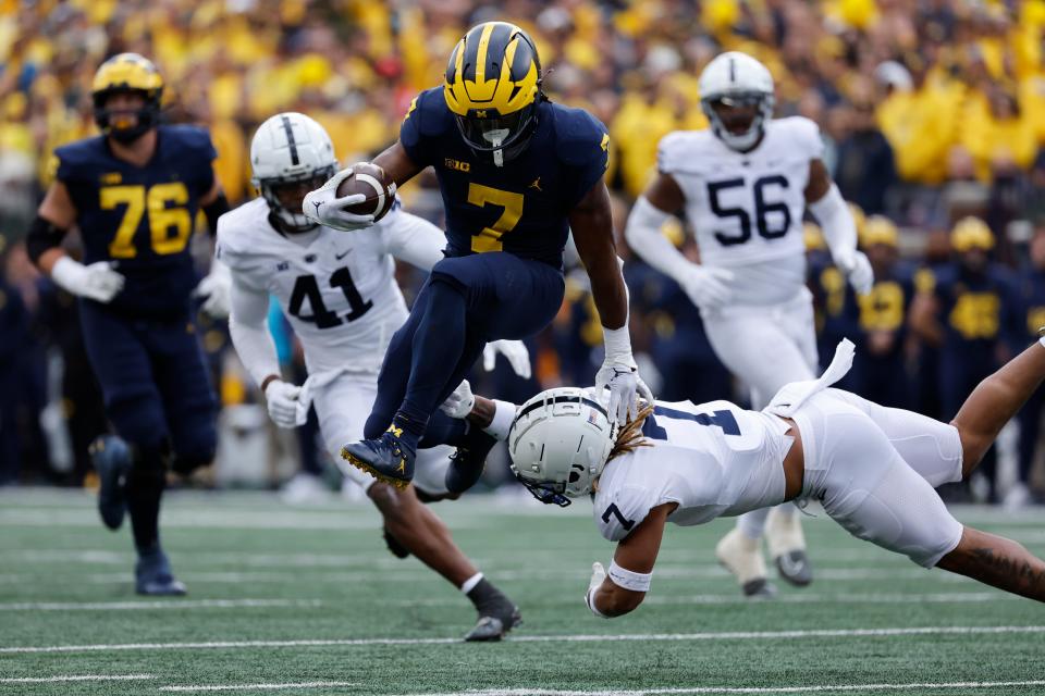 Michigan running back Donovan Edwards (7) avoids a Penn State defender while carrying the ball at Michigan Stadium.