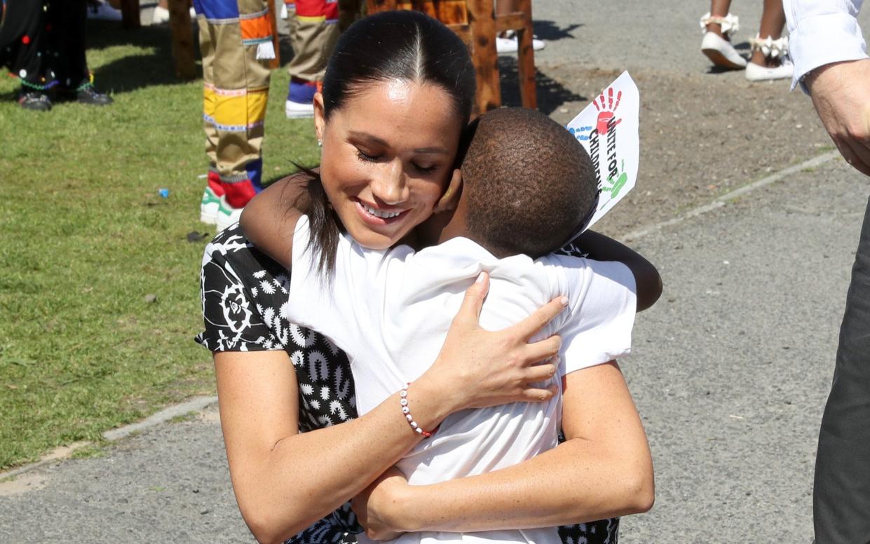 Meghan, Duchess of Sussex receives a hug from a young wellwisher as she visits a Justice Desk initiative in Nyanga township - Chris Jackson Collection